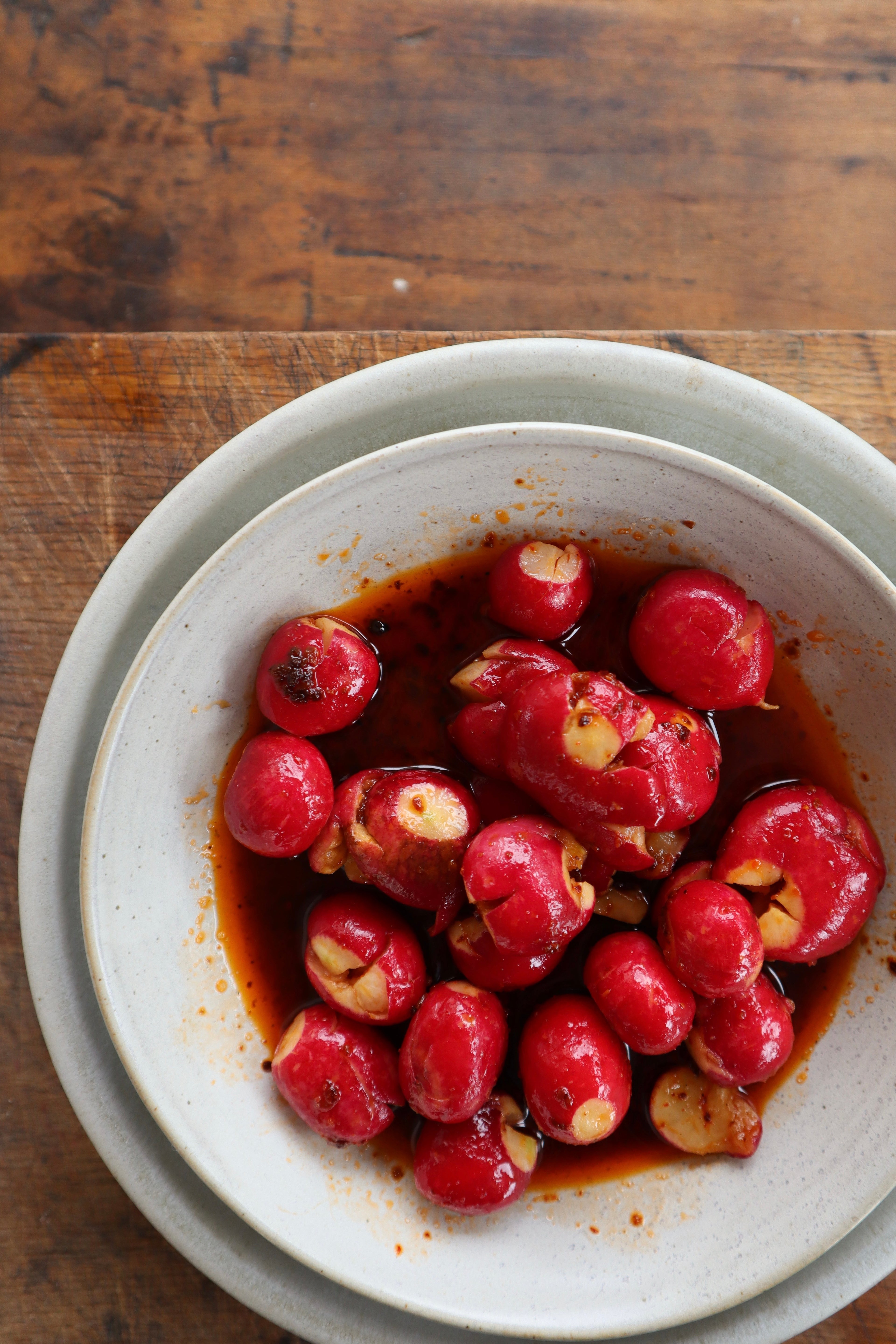 A bright bowl of pink radishes in a sauce made with White Mausu Smoky Chilli Oil. 