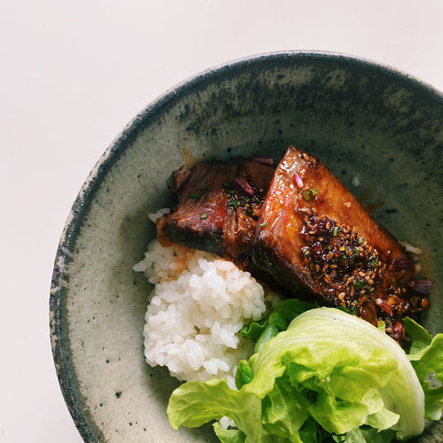 A vibrant bowl of rice topped with succulent meat, crisp lettuce, and a flavourful White Mausu Peanut Rāyu sauce, offering a satisfying dish